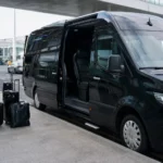 Executive minibus with corporate clients at Heathrow Airport terminal for professional client transfer service